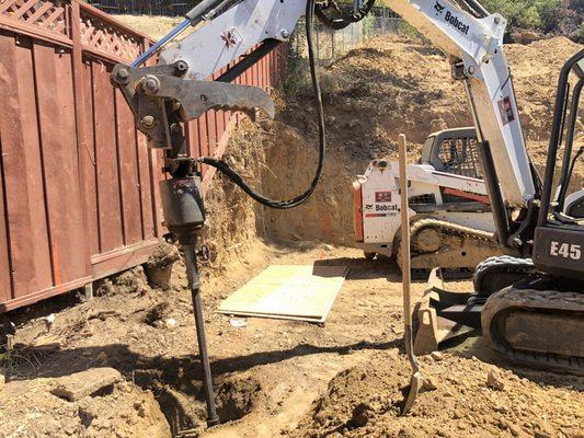 Drilling and preparing site for 18' deep pies and foundation.