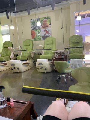 Pedicure spa chairs with screens to protect guests and nail technicians