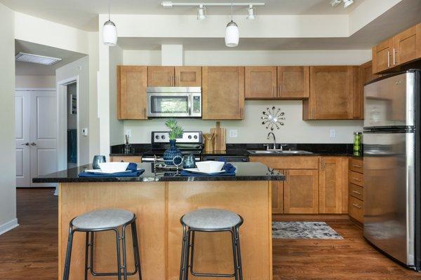 Kitchen with hardwood floors, wood cabinets, and stainless steel appliances