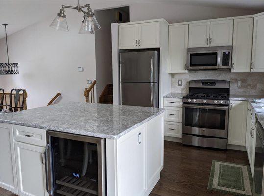 Complete kitchen remodel with new cabinets, backsplash, hardwood floors, and countertop