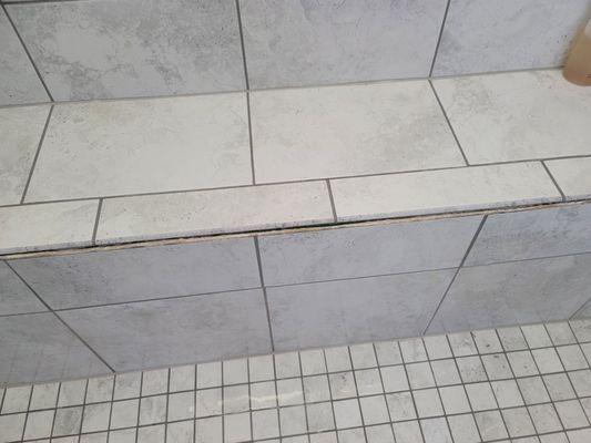 Tile pulling away from walk-in shower during a shower, starting in the middle.