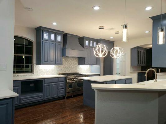 Updated kitchen with custom cabinetry, cabinet lighting, Quartz countertops, and marble backsplash tile.