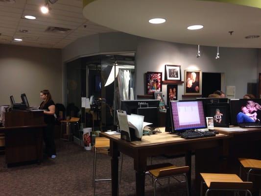 Studio includes one of two photo areas in the background, cashier on the left, and computers for reviewing photos.