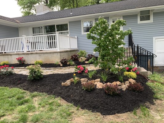 Created a landscape bed, consisting of tree with shrubs, mulch and boulders.