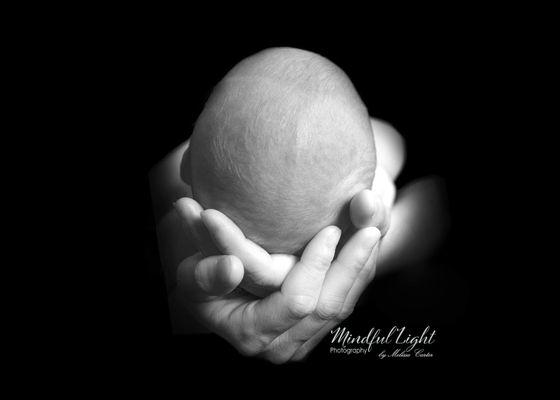 Artistic portrait of baby in moms hands photographed in Black & White at mindful Light Photography Studio in Rocky Mount VA