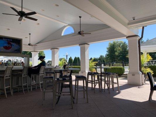 Outdoor patio and bar overlooking pool and golf course