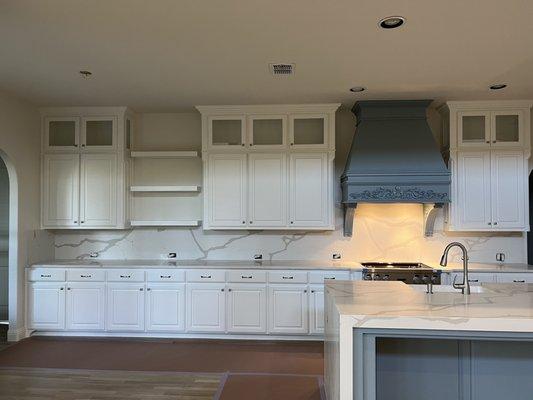 Kitchen with new upper cabinets and quartz countertop and backsplash. Floating shelves installed by Luxe as well.