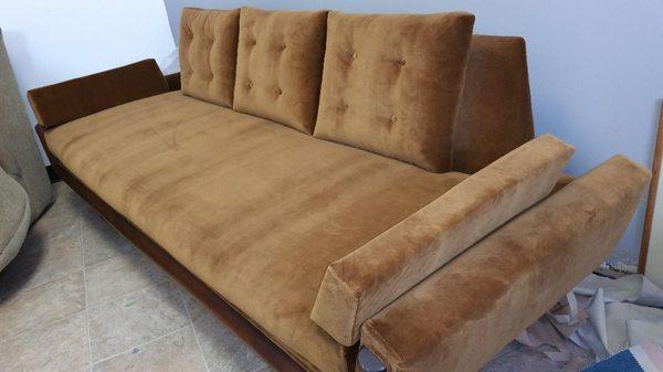 Modern tan upholstered couch with custom pillows.