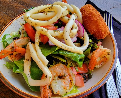 Shrimp, tender squid rings, fried crabmeat patty, with spinach, arugula, and red onion in a light & savory lemon dressing!  Ephesus Bistro