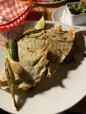 Tlayuda, made with corn tortilla, meat, onions,cilantro, and guacamole.