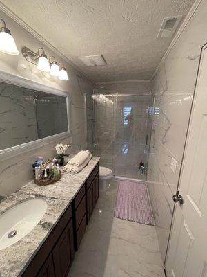 Full luxurious bathroom remodeling that includes: floor and wall tiling, shower door and shower head, vanity plumbing and countertop