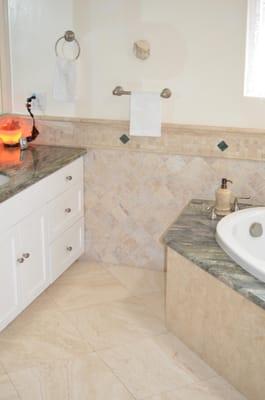 tumbled travertine wainscot with granite diamonds inserts to match the floors and tub surround