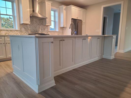 Close up of island with white cabinets and under counter  storage