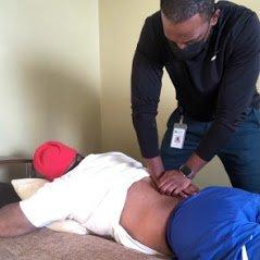 Dr. Lesly, physical therapist performing manual therapy on a client.