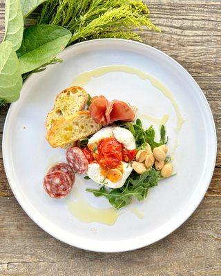 Burrata plate with truffled salami, marcona almonds and blistered tomatoes.