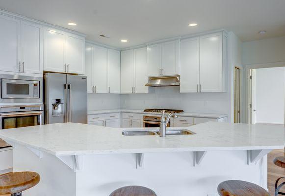 We love this white kitchen with stainless steal appliances!