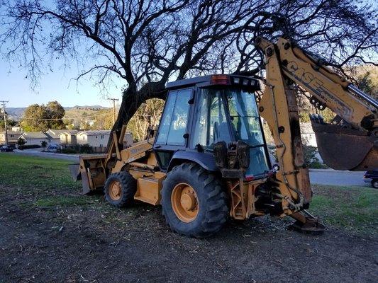 Cleaning up a property with one of our back hoes.