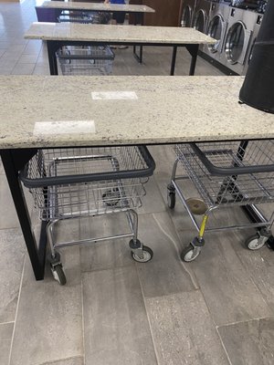 Laundry carts stored under folding tables