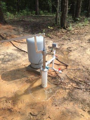 Simple hand pump installed with electric submersible pump. Can be used to fill pressure tank and supply home in a power outage.