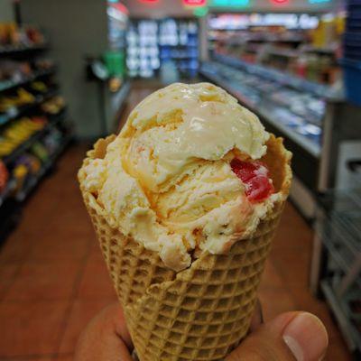 Single scoop cherry pecan ice cream in waffle cone