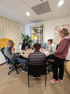 5 people around a table playing a board game