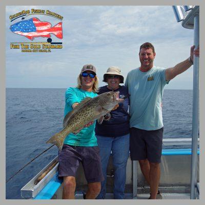 Capt. Jason and Mate Colby pose with Janice and her grouper.