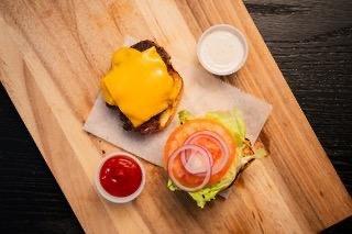 Classic Burger, ground chuck mashed seared, lettuce tomato anion mayo on sesame brioche bun