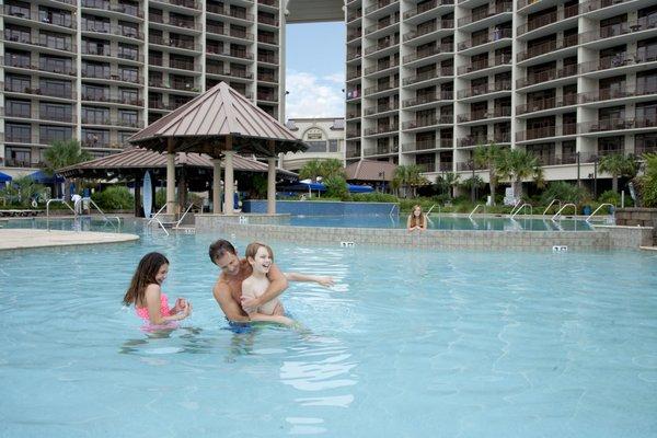 Family playing in outdoor pool