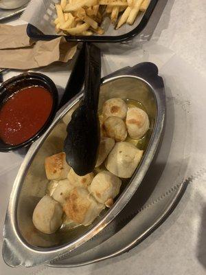 Garlic knots with butter sitting on bottom