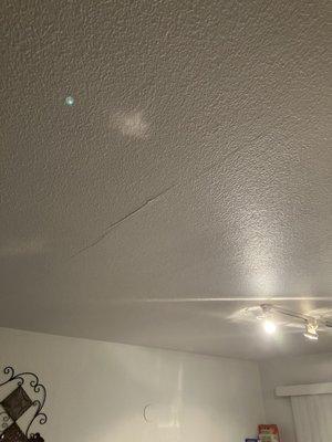 Cracks in ceiling due to water running through ceiling from bedroom into kitchen area.