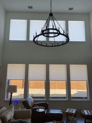 Great room with 8 power programmable roller shades in Esther white.