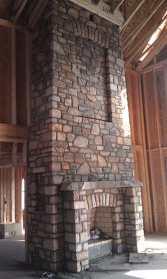 Natural stone fireplace goes up two stories.