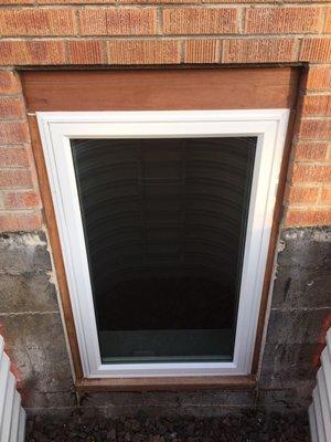 Finished egress window with redwood trim all the way around the window