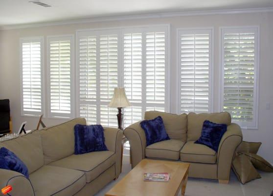 Plantation shutters installed onto a sliding glass door and the surrounding windows.