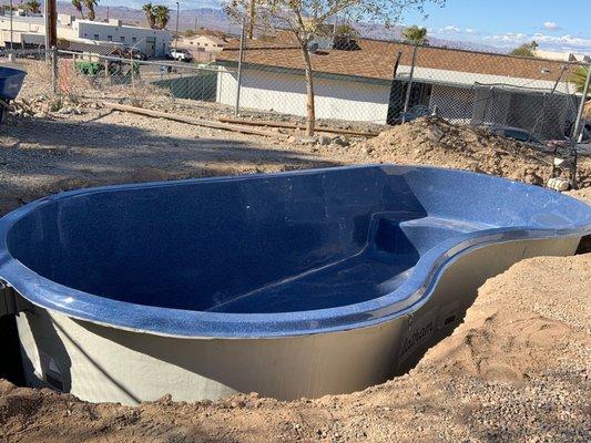 The fiberglass pool after it was set in hole.