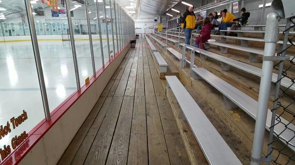 Wood bleachers, which are great to suppress the noise of kids running up and down. Very spacious.