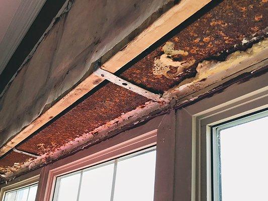 Rusted window opening lintel caused by rain entering through capstone on parapet. We installed WickRight vented flashing to stop the leaking