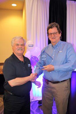 Agent Dennis Dahlin receiving a sales award from Broker Clark Segerstrom at our banquet luncheon!