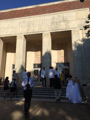 Graduation 2018. All the men wear tuxedos. All the women wear full length white gowns.