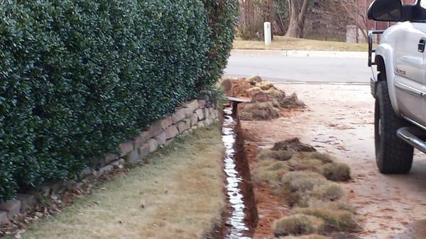 Trenching work in progress for french drains installation.