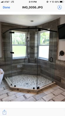 Frameless shower with header with bronze hardware