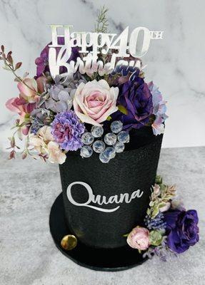 Beautiful floral birthday cake with a purple and black design.