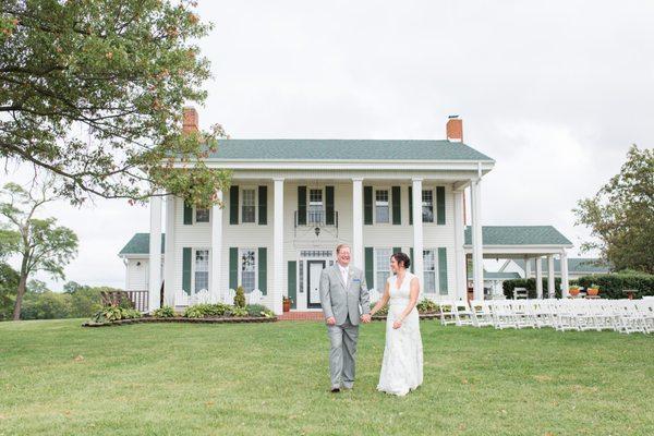 Couple beside their outdoor wedding ceremony spot on the front lawn