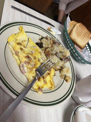 Ham and cheese omelette with home fries and toast.