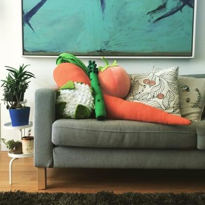 A variety of Jumbo Jibbles vegetable and fruit pillows. The 4-foot carrot body pillow is a top-seller.