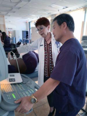 Our DMS instructor, Dr. Barbara guiding her student Daniel during lab work in our Diagnostic Medical Sonography program.