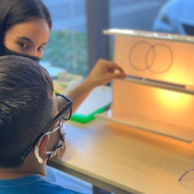 One of our therapists carefully watching eye movements of a patient with convergence insufficiency in an one-on-one vision therapy session.