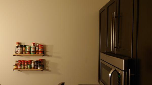 A spice rack on the wall makes life easier for the cook in the family.