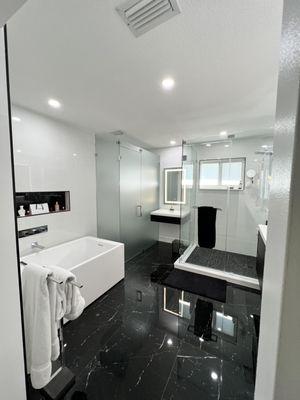 Our bathroom renovation offers privacy through a frosted glass enclosure, complemented by a contemporary freestanding tub.