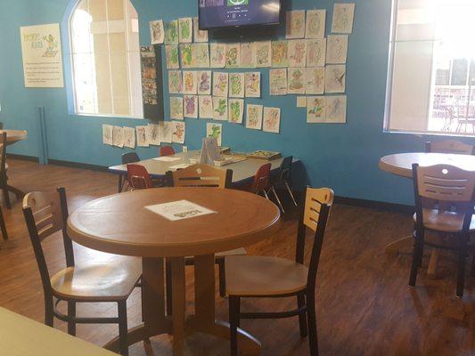 Area for parents or other guardians to sit if they like and watch the kids. Also a coloring table for kids to take a break and has puzzles.